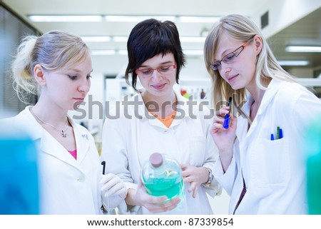 portrait of female researchers/chemistry students carrying out research in a chemistry lab (color toned image; shallow DOF)