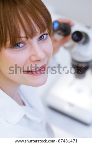 pretty female researcher/chemistry student working in a lab (shallow DOF; color toned image)
