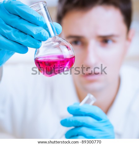 young male researcher carrying out scientific research in a lab  (shallow DOF; color toned image)