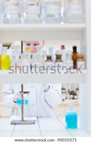 female researcher/chemistry student carrying out research in a chemistry lab (color toned image; shallow DOF)
