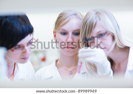 three female researchers/chemistry students carrying out research in a chemistry lab (color toned image; shallow DOF)