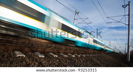 Fast train passing under a bridge on a lovely summer day (motion blurred image)