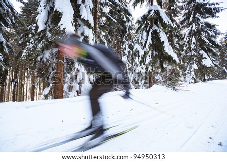 Cross-country skiing: young man cross-country skiing on a lovely sunny winter day (motion blur technique is used to convey movement)