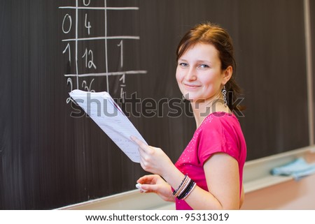 pretty young college student by the chalkboard/blackboard during a math class (color toned image)