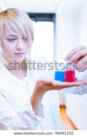 Closeup of a female researcher/chemistry student carrying out experiments in a lab (color toned image)