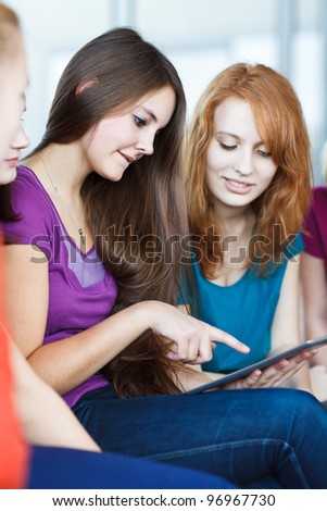 Young college students using a tablet computer in class (color toned image)