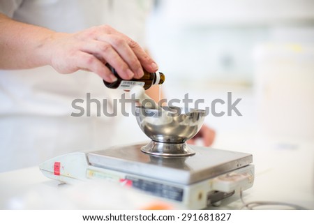 Medical industry production - worker\'s hands preparing a cream, weighing the mixture