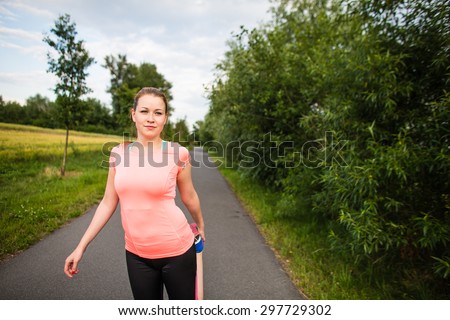 Young woman running outdoors on a lovely sunny winter/fall day - doing the necessary stretching before her run
