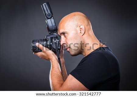 Young, pro male photographer in his studio during a photo shoot (color toned image; shallow DOF)