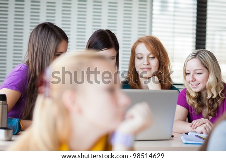 Three female college students working on their homework/having a chat in between the lectures (color toned image)