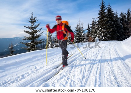 Cross-country skiing: young man cross-country skiing on a lovely sunny winter day