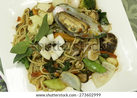 Spicy fried spaghetti with seafood on white dish