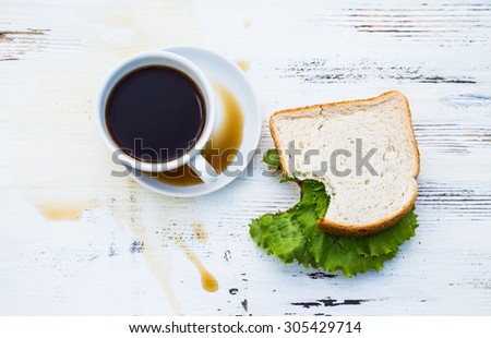 Spilled coffee and sandwich bitten