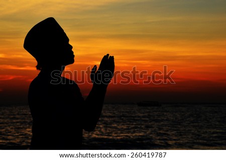 Silhouette of a Muslim praying during sunset.\
Image has grain or blurry or noise and soft focus when view at full resolution. \
(Shallow DOF, slight motion blur)