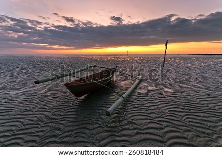 boat with sand texture at sunset during low light. Borneo, Sabah, Malaysia Image has grain or blurry or noise and soft focus when view at full resolution.  (Shallow DOF, slight motion blur)