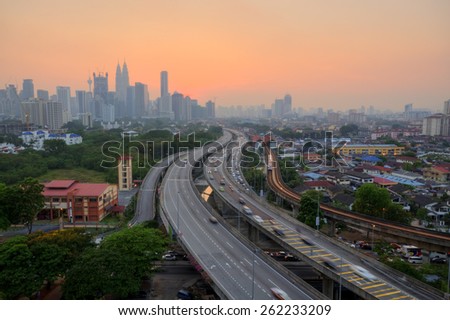 Kuala Lumpur City skyline at sunset\
Image has grain or blurry or noise and soft focus when view at full resolution. (Shallow DOF, slight motion blur)