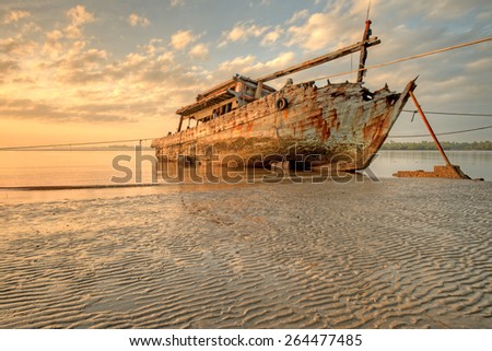 Abandoned Ship during sunrise moment at sabah borneo malaysia Image has grain or blurry or noise and soft focus when view at full resolution.  (Shallow DOF, slight motion blur)