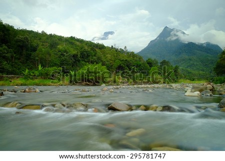 Scenic tropical landscape of To Tambatuon Valley, Kota Belud, Sabah, Malaysia with Mount Kinabalu as background. (Shallow DOF, slight motion blur)