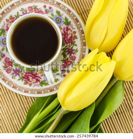 Porcelain tea cup with yellow tulip flowers
