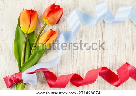 Empty wooden background with colorful flowers and ribbon