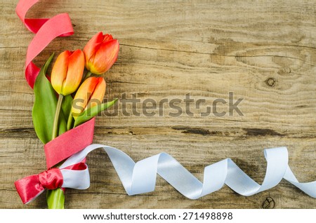 Empty wooden background with colorful flowers and ribbon