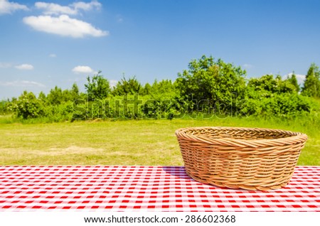 Empty table with wicker basket and landscape background