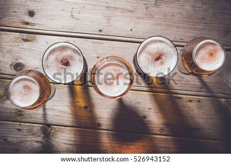 Glasses of beer on an old wooden table. Top view