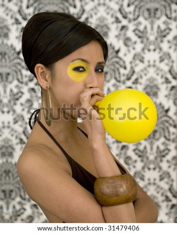 stock photo : Beautiful asian model with funky make-up blow balloon