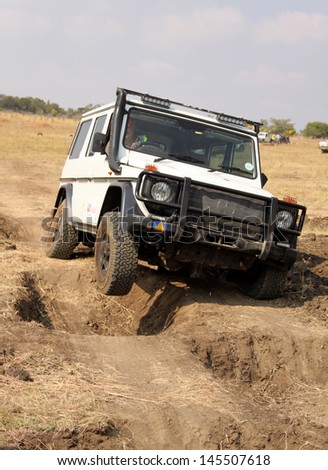 BAFOKENG - MAY 18: White Mercedes-Benz G-Class scaling deep holes obstacles at new 4x4 track opening event May 18, 2013 in Bafokeng, Rustenburg, South Africa