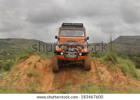 BAFOKENG - MARCH 8: Crush Beige Jeep Wrangler Off-Roader V8 crossing obstacle at Leroleng 4x4 track on March 8, 2014 in Bafokeng, Rustenburg, South Africa