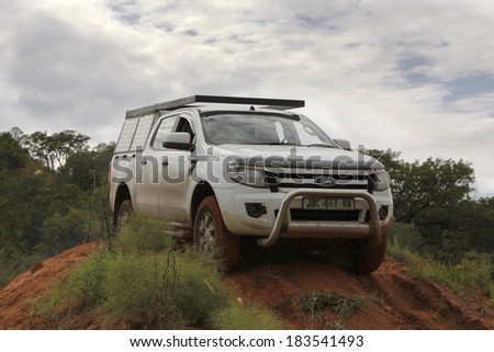 BAFOKENG - MARCH 8: White Ford Ranger XLS with Silver Canopy crossing obstacle at Leroleng 4x4 track on March 8, 2014 in Bafokeng, Rustenburg, South Africa