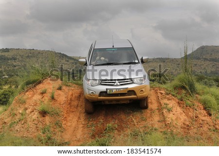 BAFOKENG - MARCH 8: Silver Toyota Triton DHD crossing obstacle at Leroleng 4x4 track on March 8, 2014 in Bafokeng, Rustenburg, South Africa