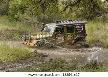 BAFOKENG - MARCH 8: Gecko Pearl Green Jeep Wrangler Rubicon crossing muddy pond obstacle at Leroleng 4x4 track on March 8, 2014 in Bafokeng, Rustenburg, South Africa