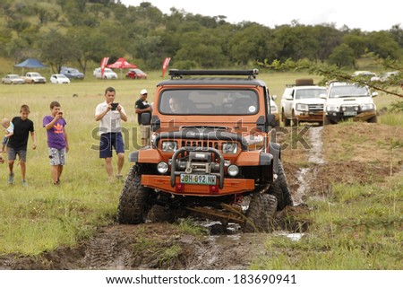 BAFOKENG - MARCH 8: Crush Beige Jeep Wrangler Off-Roader V8 crossing water obstacle at Leroleng 4x4 track on March 8, 2014 in Bafokeng, Rustenburg, South Africa