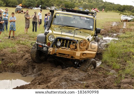 BAFOKENG - MARCH 8: Gecko Pearl Green Jeep Wrangler Rubicon crossing mud obstacle at Leroleng 4x4 track on March 8, 2014 in Bafokeng, Rustenburg, South Africa