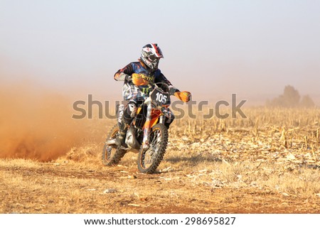 BRITS, SOUTH AFRICA - July 11:  Africa-Offroad Racing Rally,  on July 11, 2015 at Koster, North West Province, South Africa.  Motorbike kicking up trail of dust on sand track during rally race.