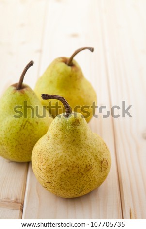 Three green pears on clear wood table