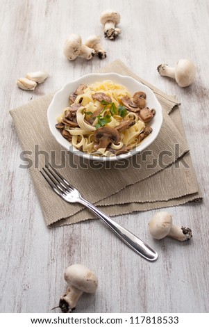 Dish of noodles with mushroom on wood table