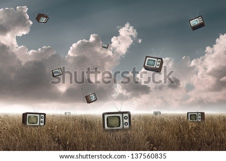 Many television falling to the sky in a meadow