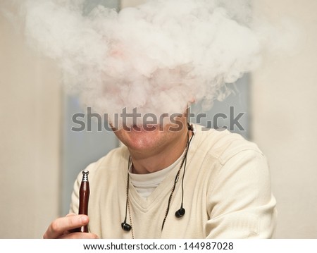 man is a smoking hookah.portrait is in the volumes of smoke.