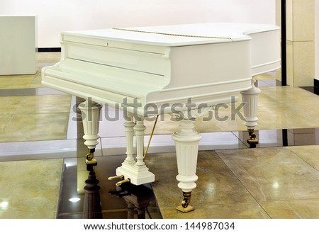White concerto piano is in an interior.Classic musical instrument.