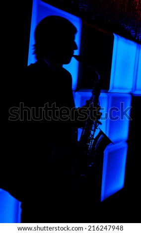 Man with saxophone on a blue background.Silhouette,