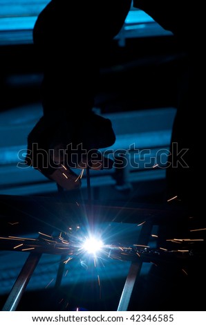close up of worker welding with blue background