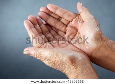 an old lady open hands against grey background