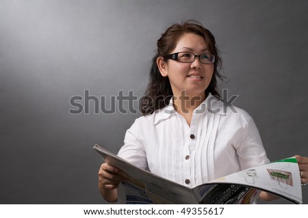 asian woman smiling while reading newspaper with copy space