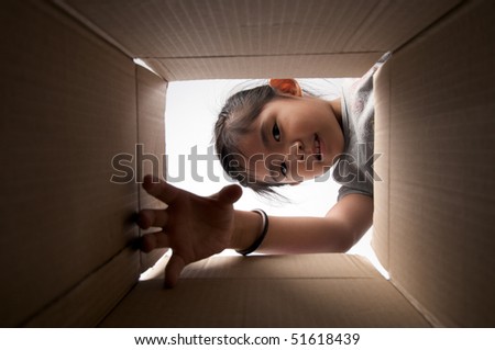 girl reaching for something inside the box