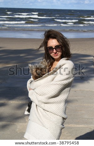 Young beautiful woman with her dog on a beach