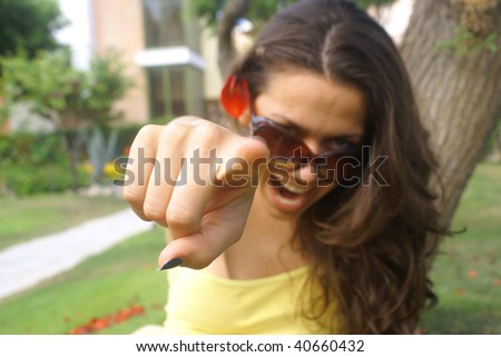 Young female pointing at you . Portrait of an attractive young woman pointing her finger.