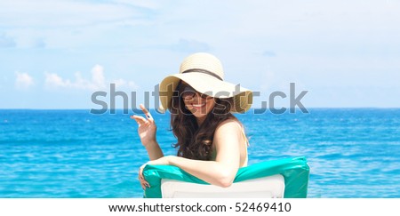Woman sunbathing on plastic chair at the beautiful beach