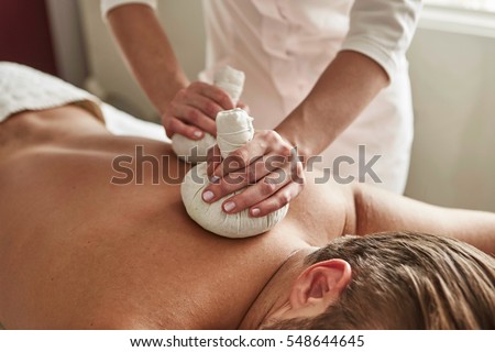 hands massage man\'s back in wellness salon